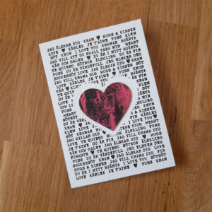 Vitt kort med kärleksfulla ord stämplat i svart. Ett hjärta i rosa och svart i mitten.