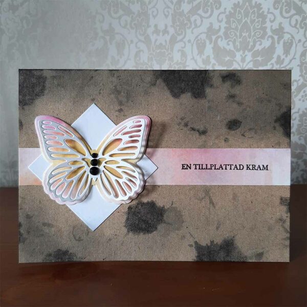 Liggande kort med fjäril och texten en tillplattad kram.